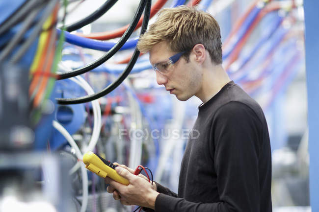 MID дорослий чоловічий технік випробувальні кабелі в інженерній заводі — стокове фото
