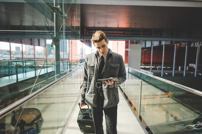 Portrait of young businessman commuter using digital tablet at train station. — Stock Photo