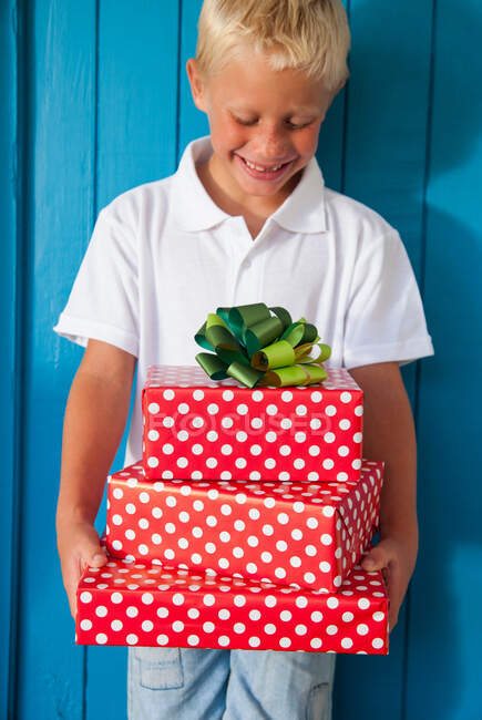 Boy looking down at gifts — Stock Photo