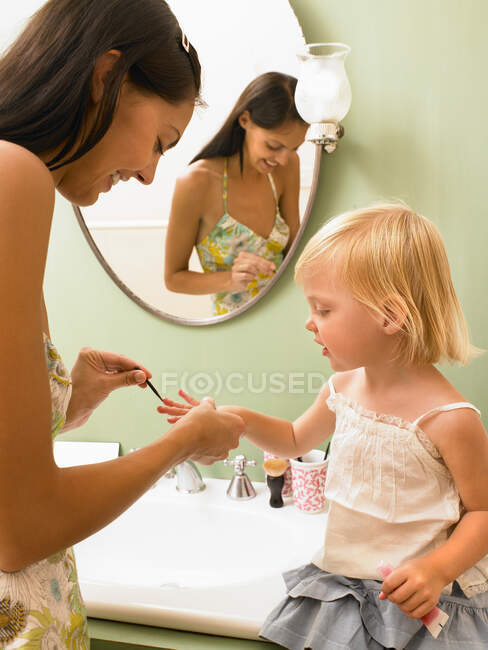 Mãe e filha aplicando maquiagem — Fotografia de Stock