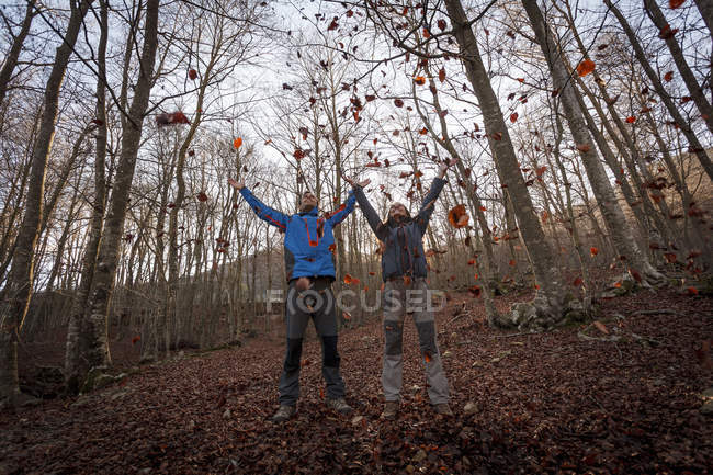 Hikers throwing leaves in woods, Montseny, Barcelona, Catalonia, Spain — Stock Photo