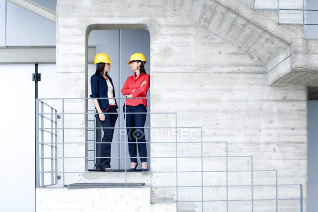 Femmes d'affaires en casque de sécurité sur le balcon de l'immeuble — Photo de stock