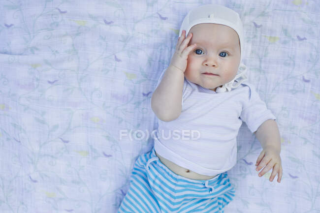 Portrait of baby girl touching face — Stock Photo