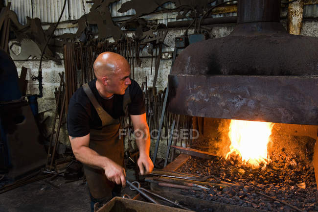 Male caucasian blacksmith at work in workshop — Stock Photo