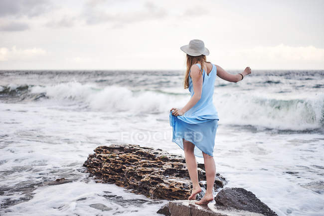 Жінка насолоджується прогулянкою по каменях у морі — стокове фото