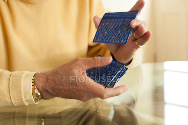 Les mains féminines âgées mélangeant les cartes à jouer — Photo de stock
