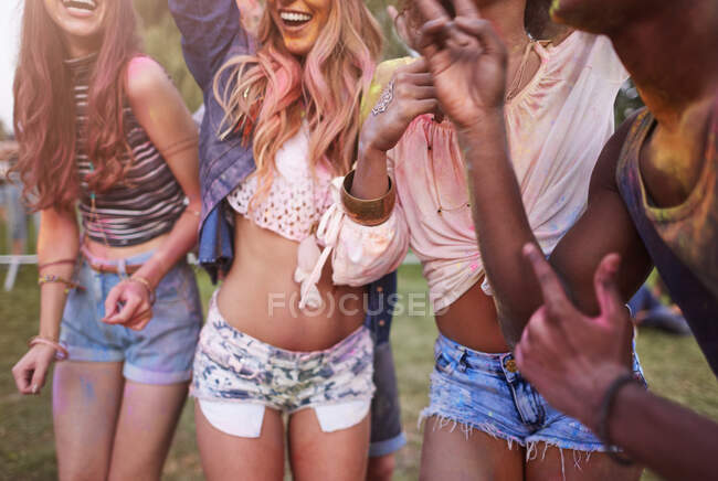 Група друзів на фестивалі, покрита барвистою порошковою фарбою, середня секція — стокове фото