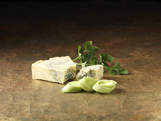 Puerros en rodajas, queso stilton y cilantro en el mostrador de la cocina - foto de stock