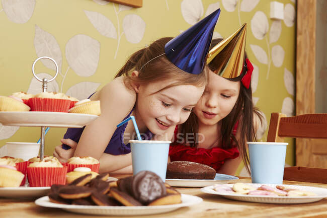 Дві дівчини дивляться на торт — стокове фото