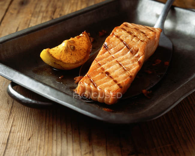 Grilled salmon with lemon wedge in baking tin — Stock Photo