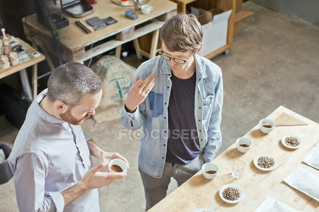 Propietario del café y cliente discutiendo café - foto de stock