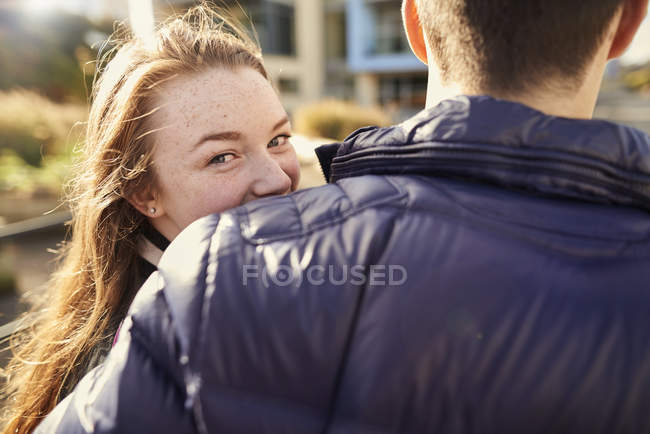 Two friends walking outdoors, young woman looking over shoulder, rear view, Bristol, UK — Stock Photo