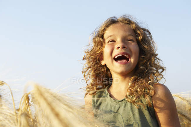 Menina sorrindo em um campo de trigo — Fotografia de Stock