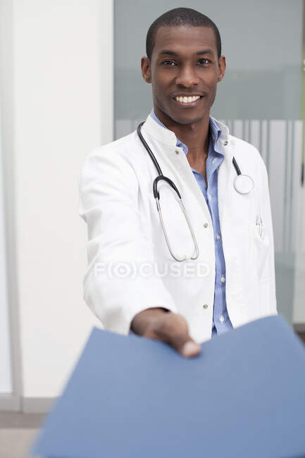 Doctor handing over paperwork — Stock Photo