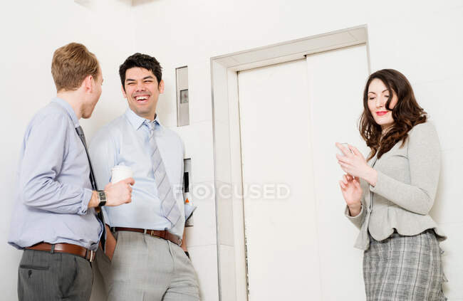 Colleagues waiting by elevator — Stock Photo