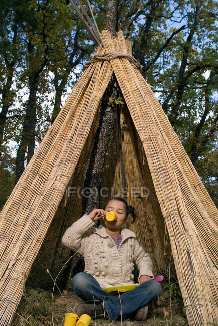 Kids playing in a teepee drinking tea — Stock Photo