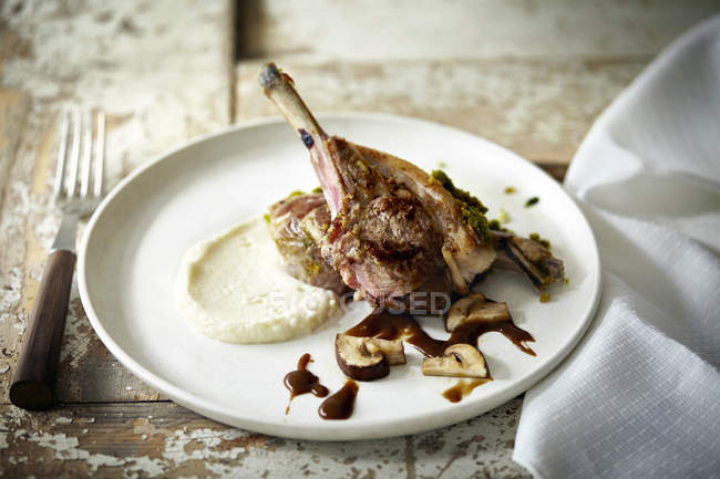 Assiette avec côtelette d'agneau, sauce et purée de pommes de terre — Photo de stock