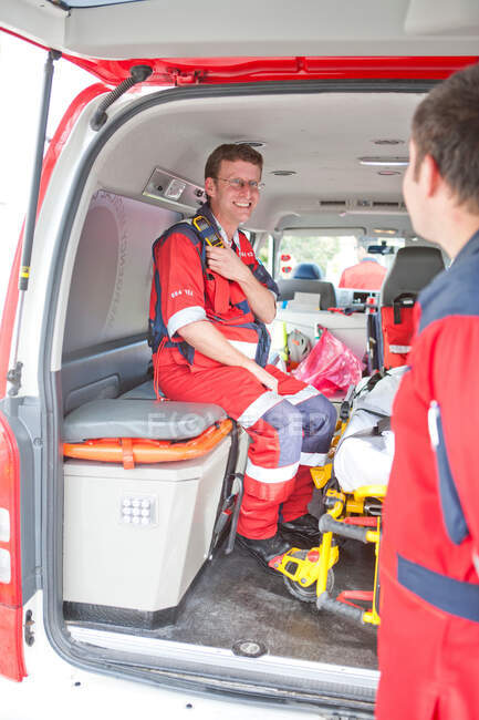 Paramédico en ambulancia esperando llamada - foto de stock
