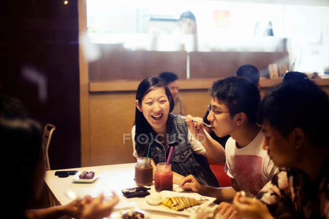 Friends eating dessert in cafe — Stock Photo