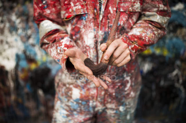 Mid section of male ship painter holding paint brush — Stock Photo