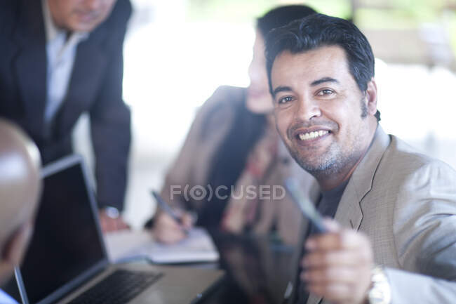 Businesspeople sitting around laptop — Stock Photo