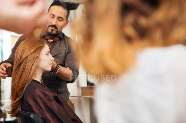 Cabeleireiro masculino styling cabelo vermelho do cliente no salão de cabeleireiro — Fotografia de Stock