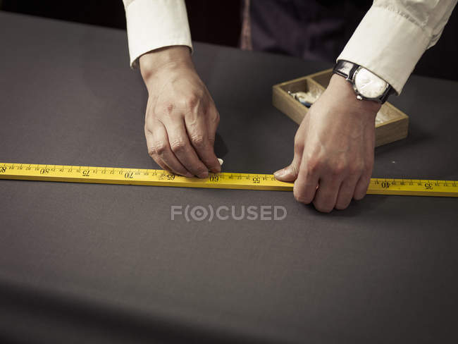 Tailor chalking measurements on table in traditional tailors shop — Stock Photo