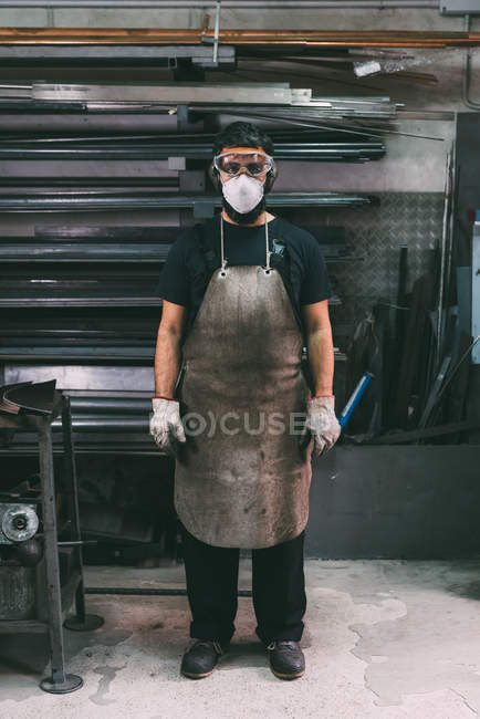 Retrato de hombre metalúrgico en máscara de polvo, almacén de forja - foto de stock