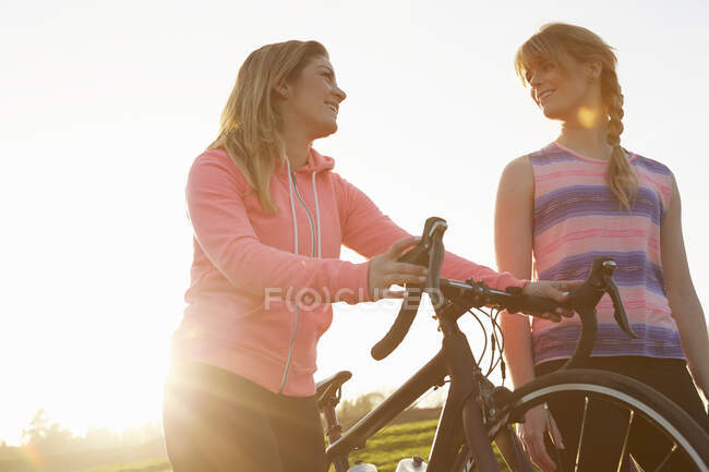 Женщины-велосипедистки прогуливаются на велосипеде в солнечном парке — стоковое фото