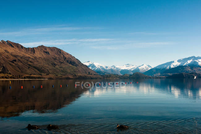 Montañas y cielo reflejados en el lago - foto de stock