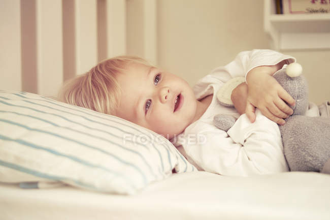 Retrato de bebê menina deitada na cama — Fotografia de Stock