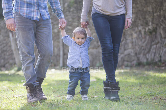 Low section of parents holding baby boys hands — Stock Photo