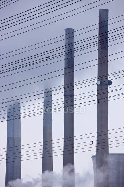 Труби вугільної електростанції та лінії електропередач — стокове фото