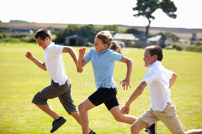 Bambini sorridenti che corrono sul campo, focus selettivo — Foto stock