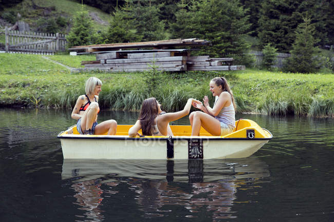 Three adult female friends having fun in rowing boat on lake, Sattelbergalm, Tirol, Austria — Stock Photo