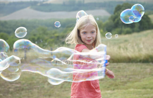 Mädchen spielt mit Seifenblasen — Stockfoto