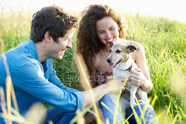 Coppia con cane in un campo di grano — Foto stock