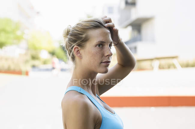 Ritratto di giovane atleta donna in piedi sulla strada — Foto stock