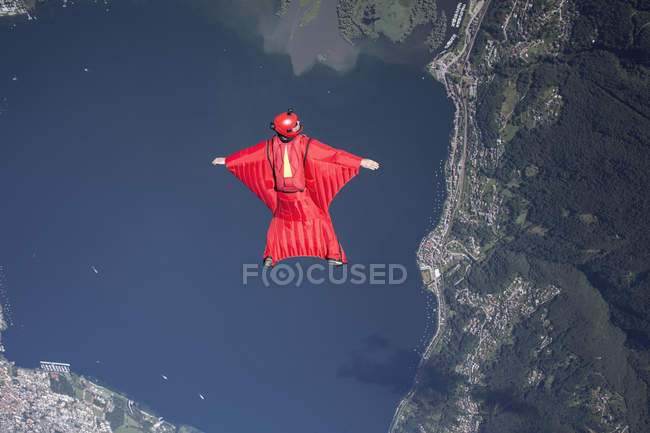 Wingsuit Fallschirmspringer Pilot fliegt über See, Locarno, Tessin, Schweiz — Stockfoto