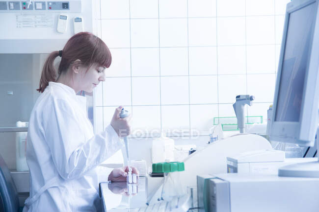 Scientifique remplissant les éprouvettes en laboratoire — Photo de stock