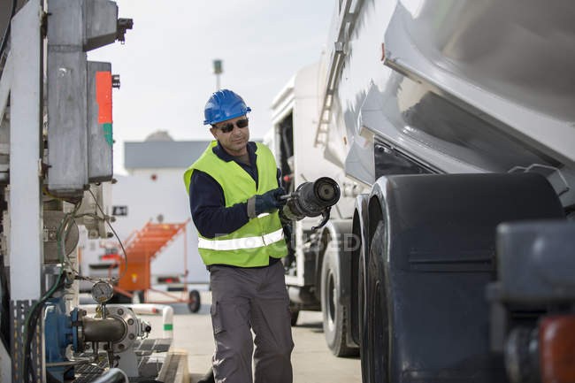 Male worker pumping fuel at fuel depot — Stock Photo