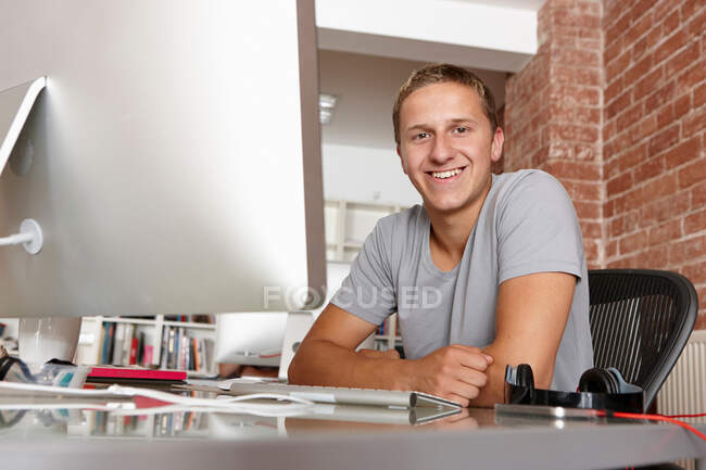 Retrato del joven en el escritorio - foto de stock