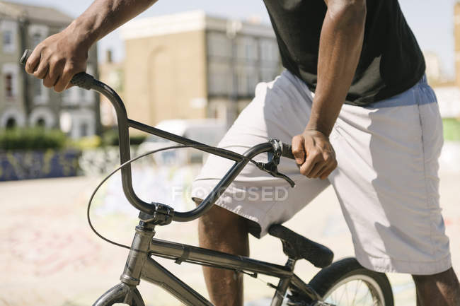 Plan recadré de jeune homme sur vélo BMX dans le skatepark — Photo de stock