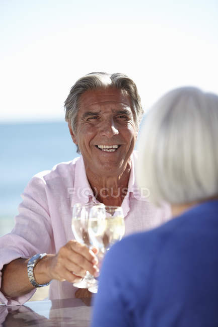 Casal desfrutando de vinho à beira-mar — Fotografia de Stock