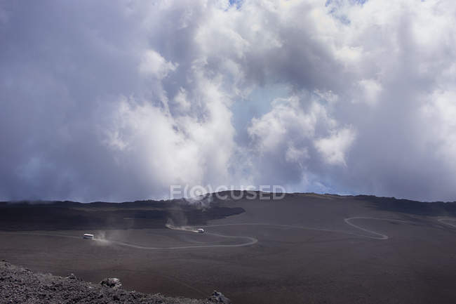 Distant view of tour buses on winding road, Mount Etna, Catania, Sicily, Italy — Stock Photo