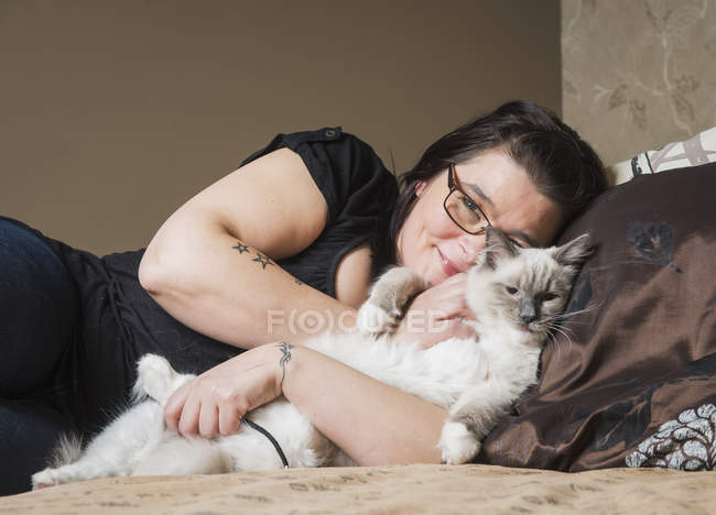 Портрет кота Раґли з власником, розслабляючись на ліжку — стокове фото