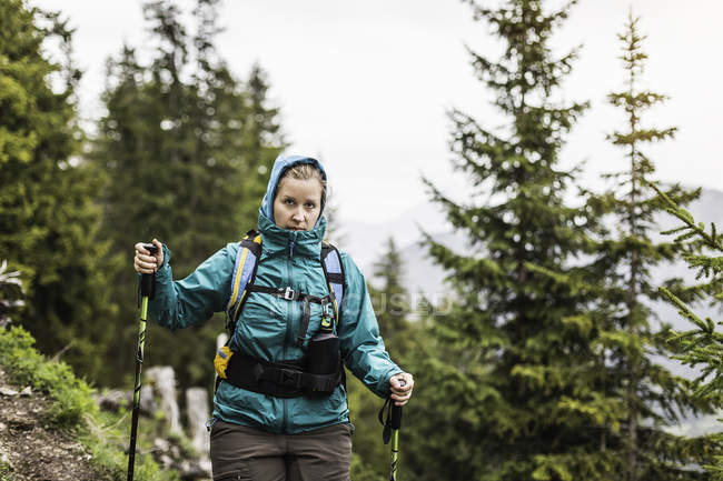 Young woman hiking with walking poles down from Zinken mountain, Oberjoch, Bavaria, Germany — Stock Photo