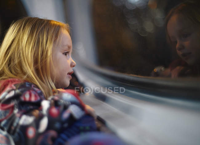 Дівчина дивиться з вікна автобус під час подорожі по ночах — стокове фото