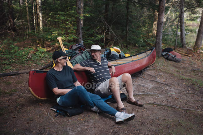 Couple sénior relaxant à côté du canot — Photo de stock