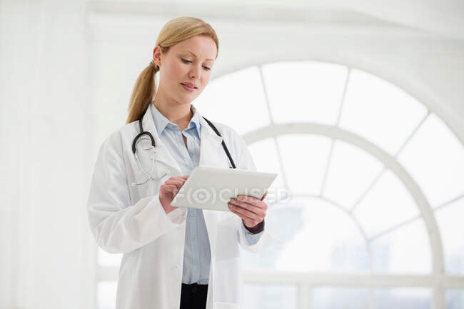 Portrait of female doctor with stethoscope and digital tablet — Stock Photo
